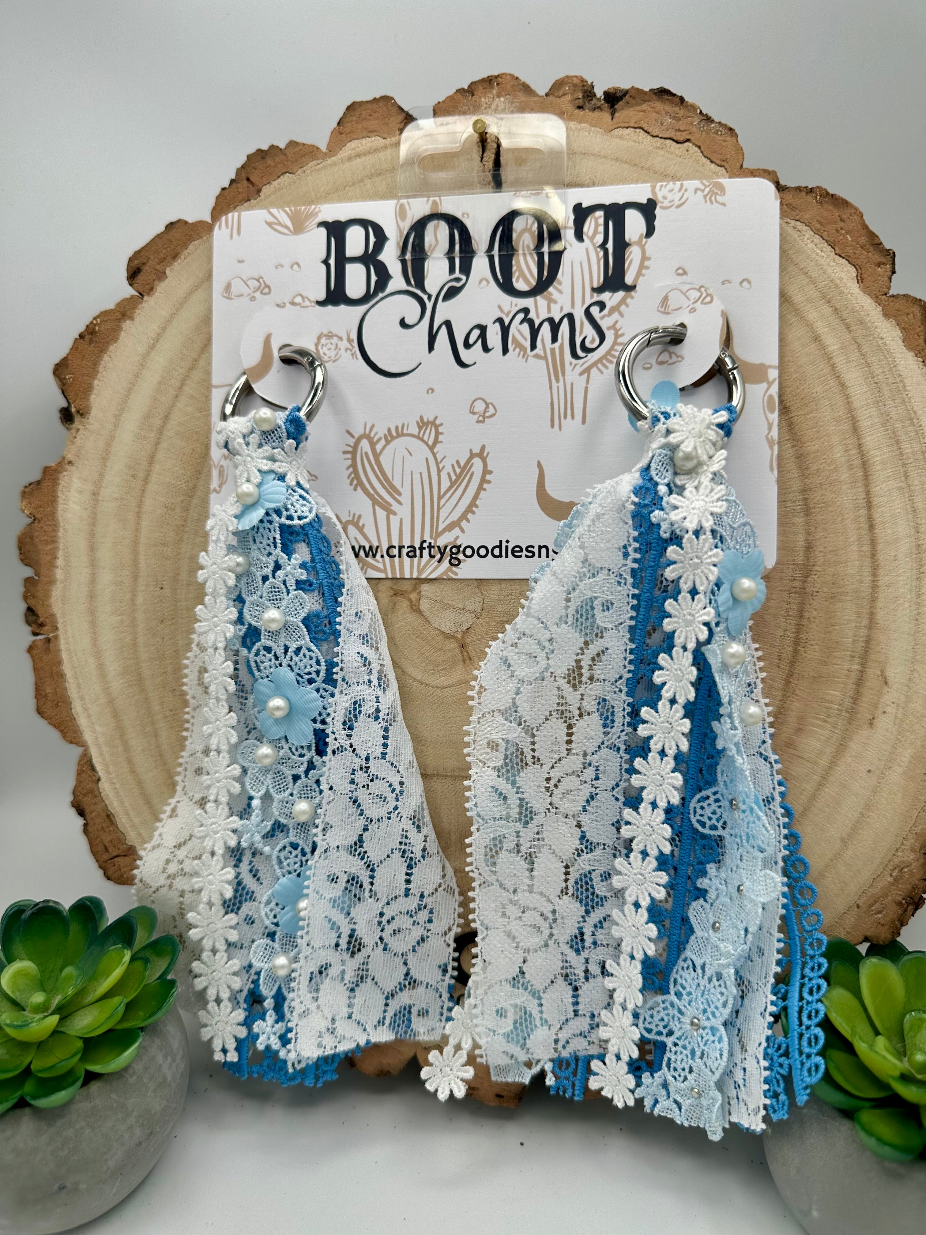 A pair of handmade boot charms with blue and white lace.