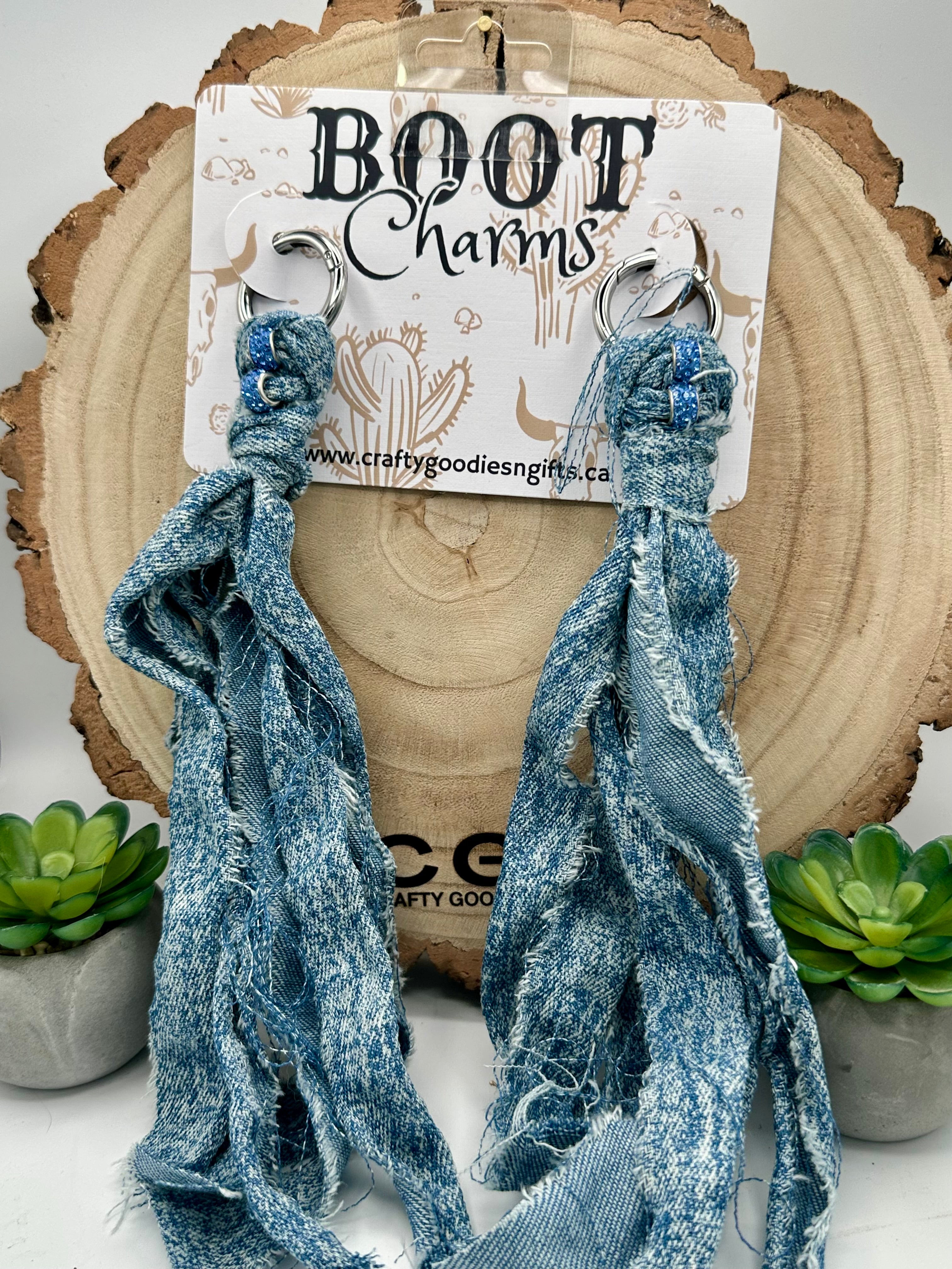 A pair of distressed blue denim boot charms with silver-tone rings