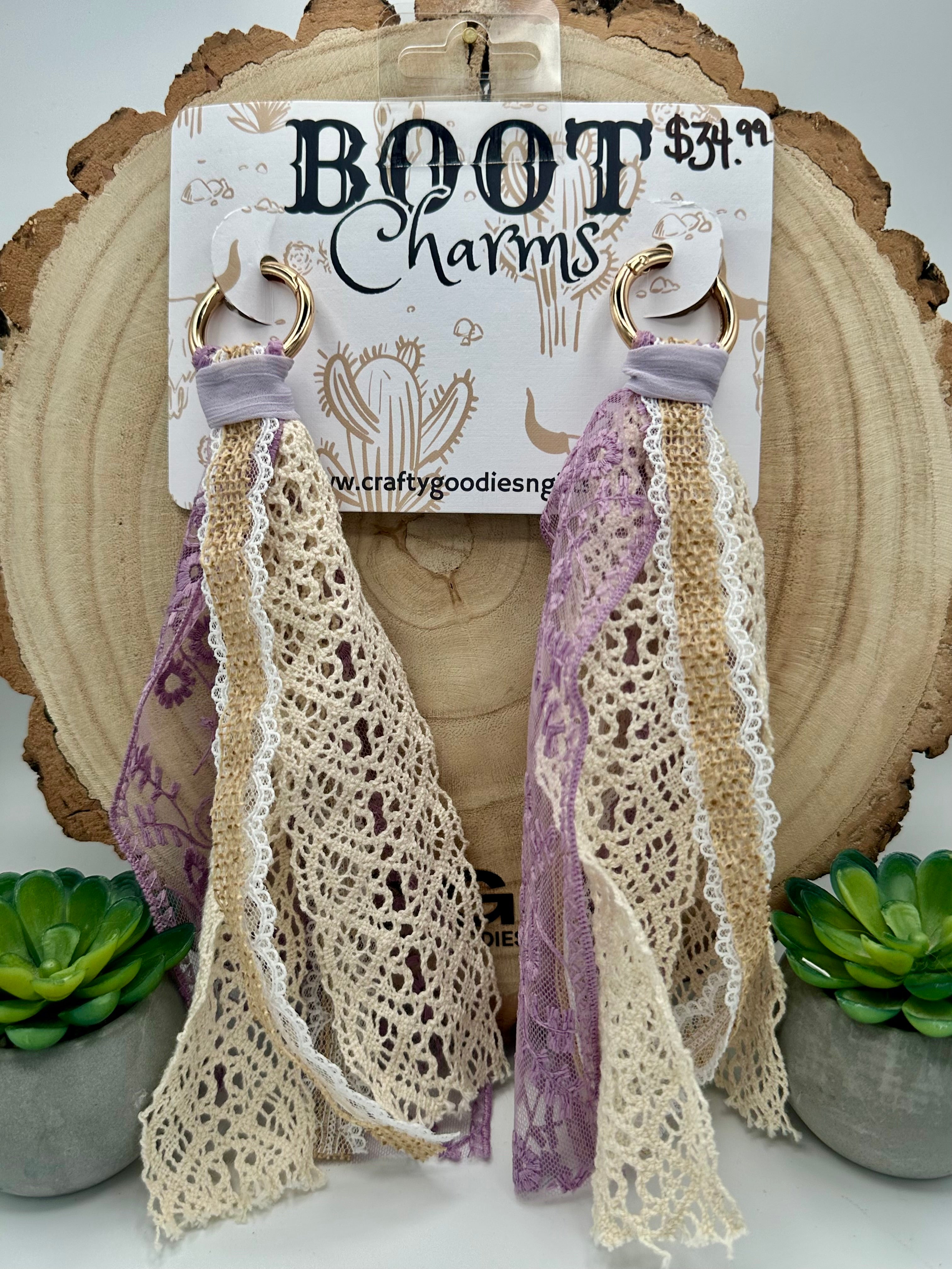A pair of lace boot charms with lavender purple and cream crochet details, hanging from gold-tone rings.