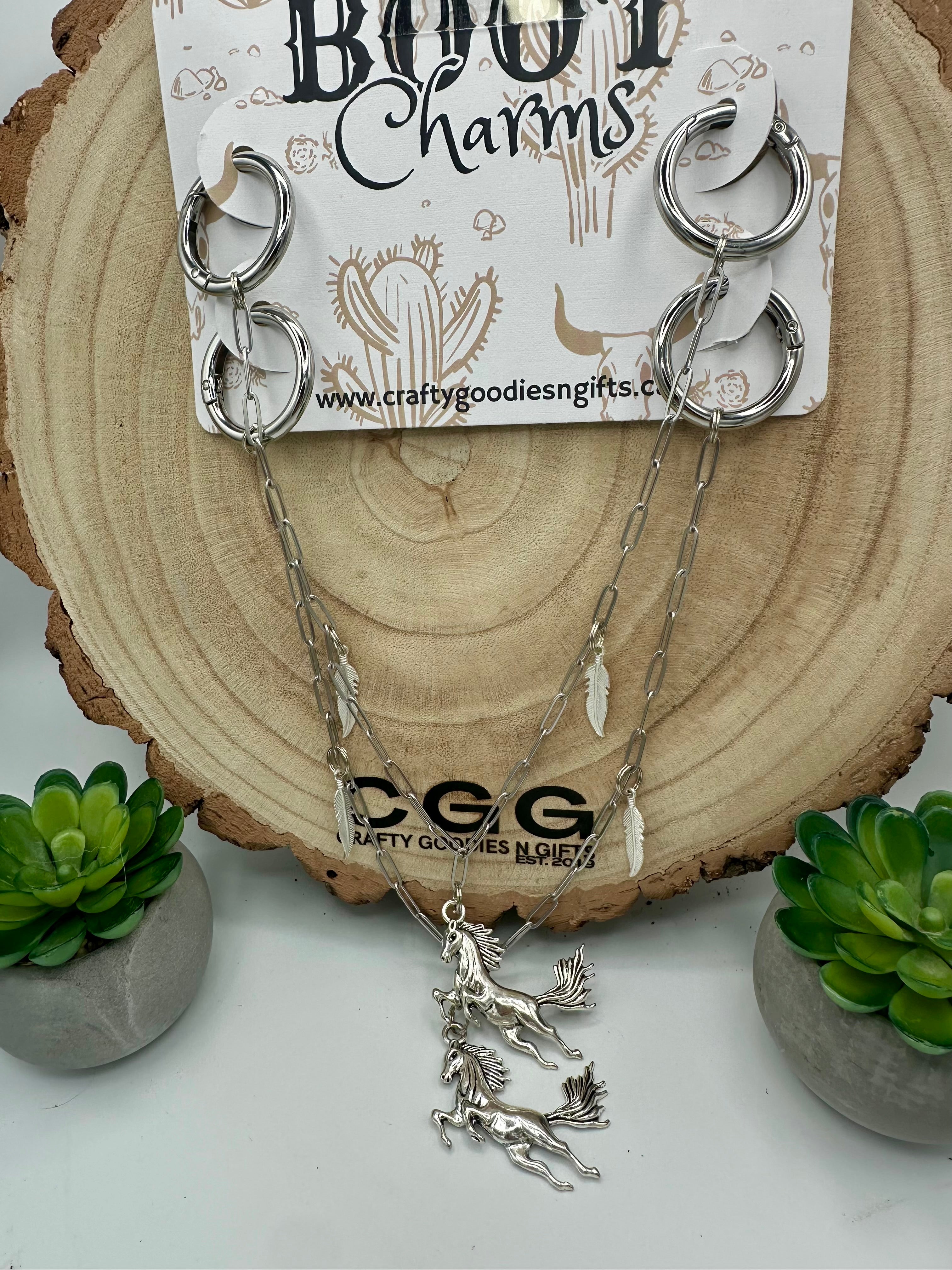 A pair of silver boot charms  featuring a horse motif.