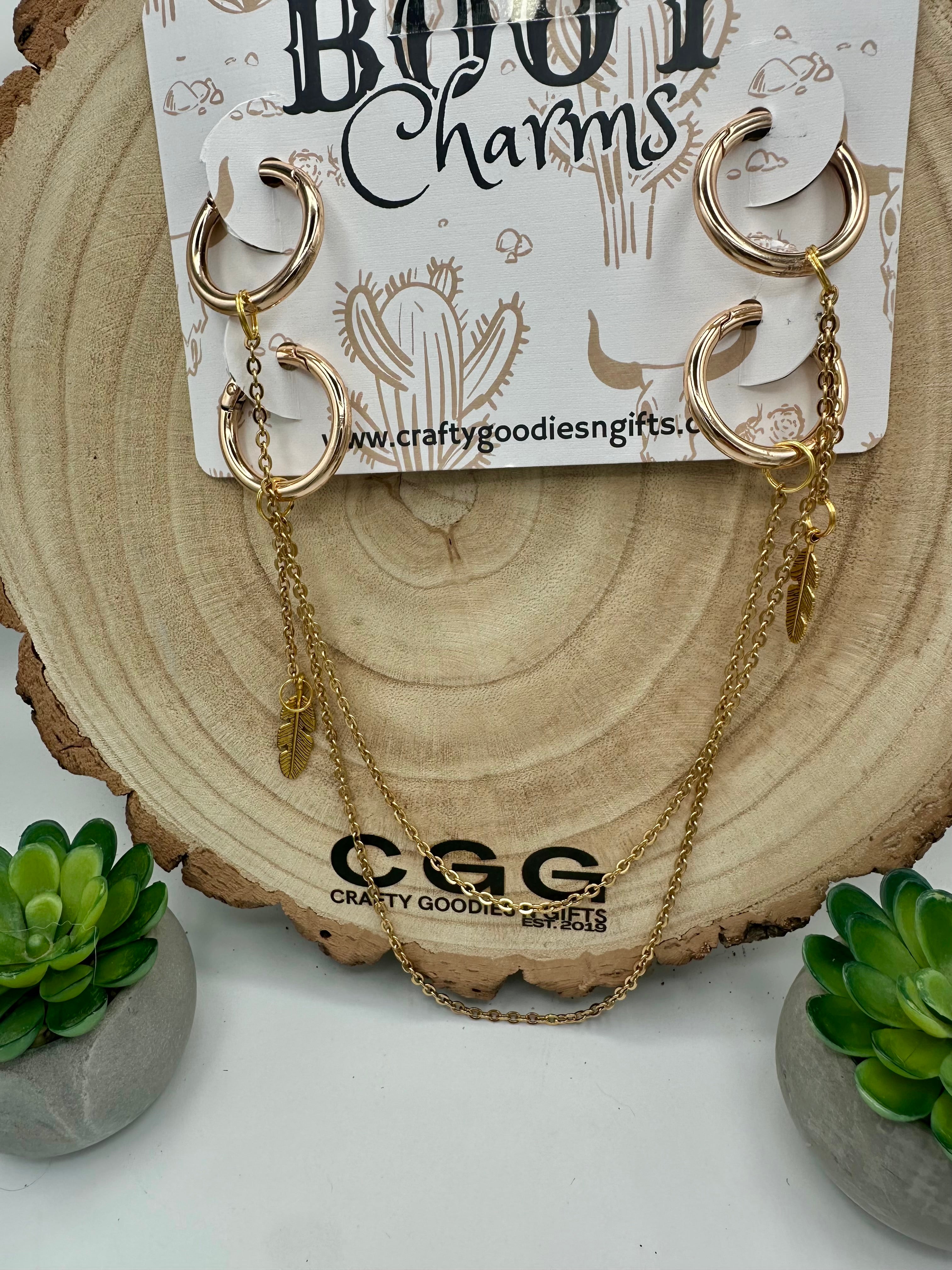Gold hooped boot charms with a dangling gold leaf on each end. 