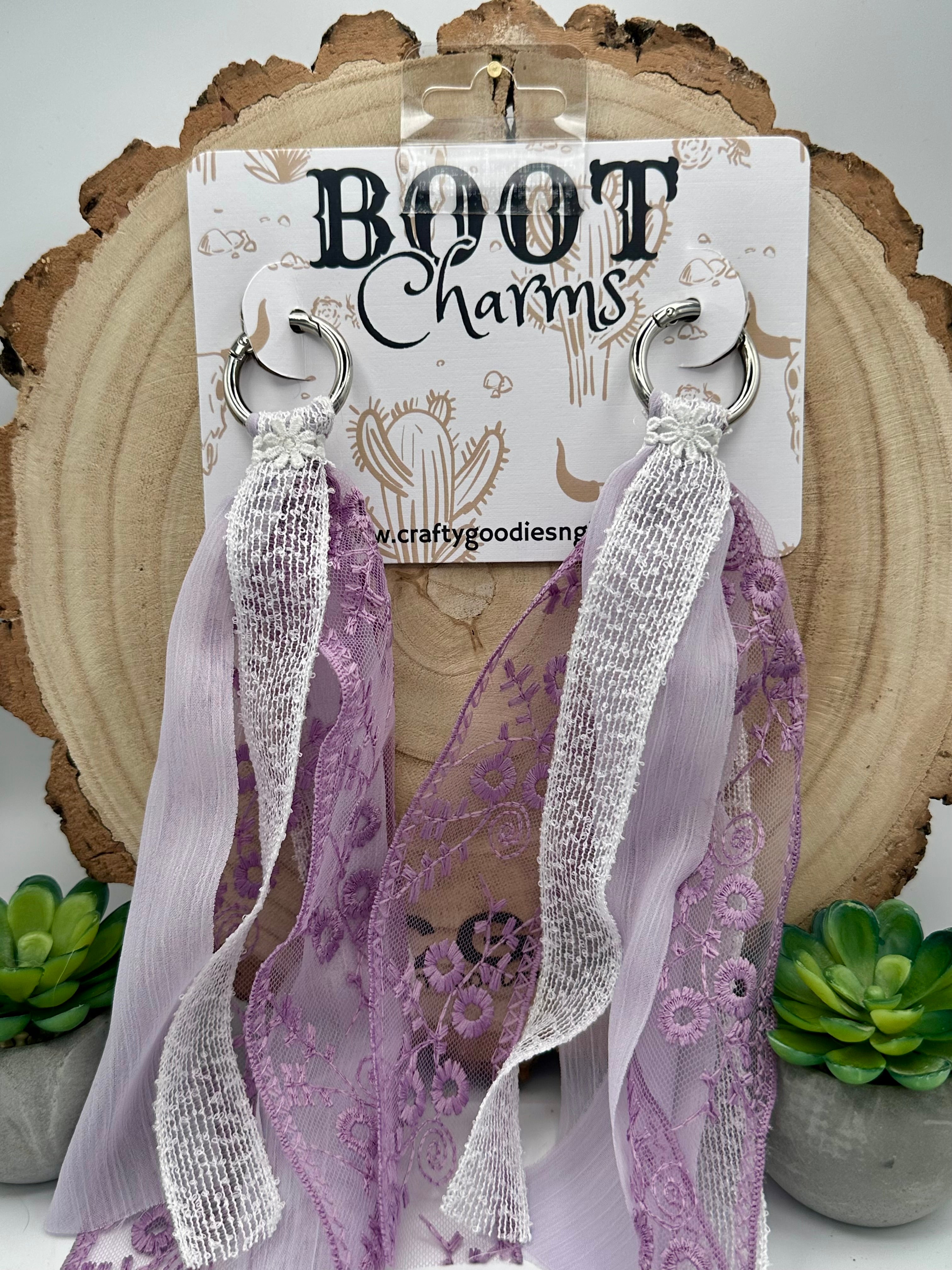 A pair of lavender and white lace boot charms with silver-tone metal rings.
